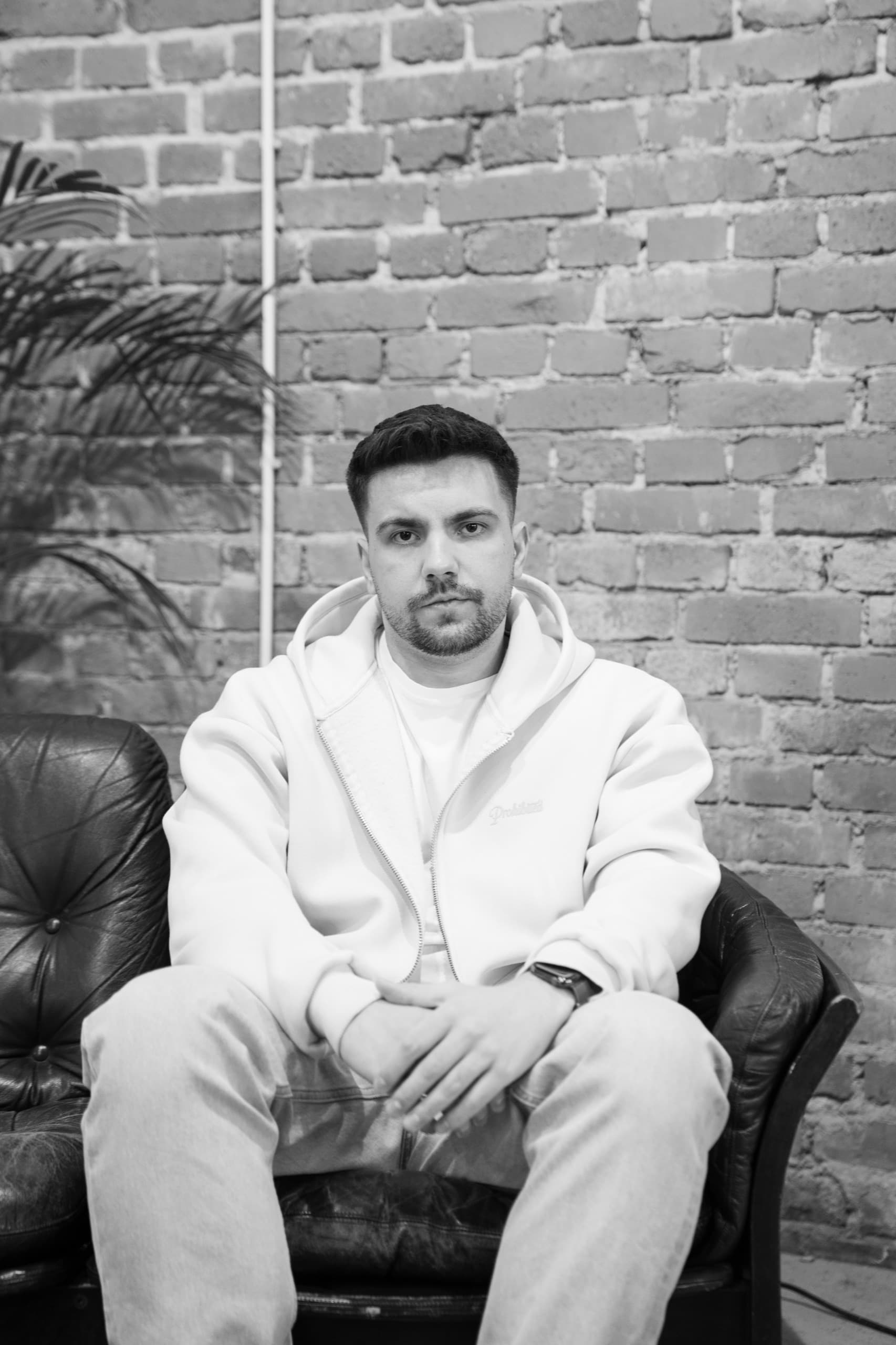 DJ MVM Schwarzweiß-Portrait auf Ledersofa